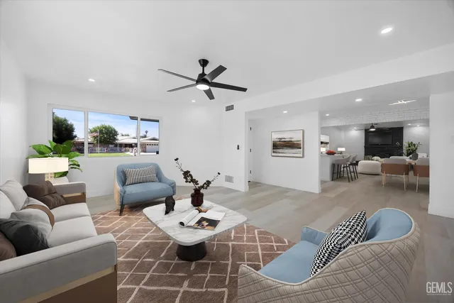 a living room with furniture and view of kitchen
