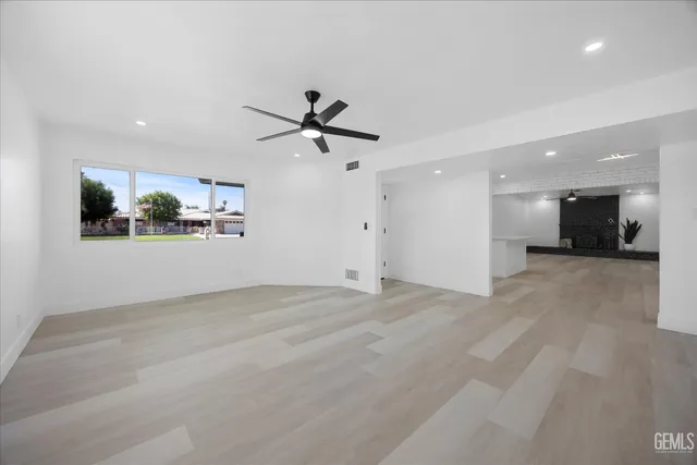 a view of a livingroom with a ceiling fan a window and a potted plant