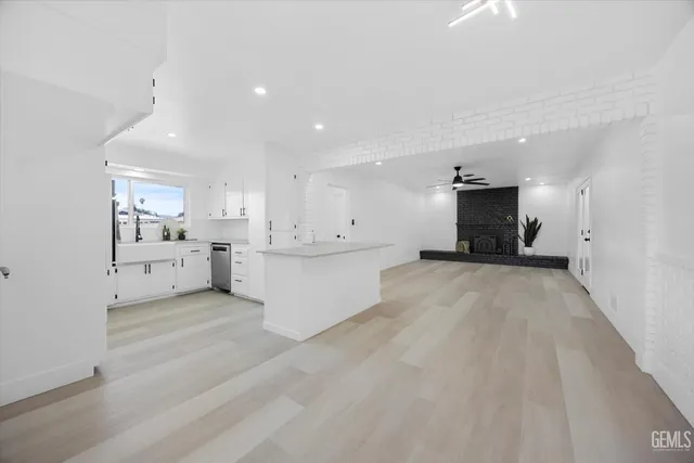 a view of kitchen with white cabinets and sink