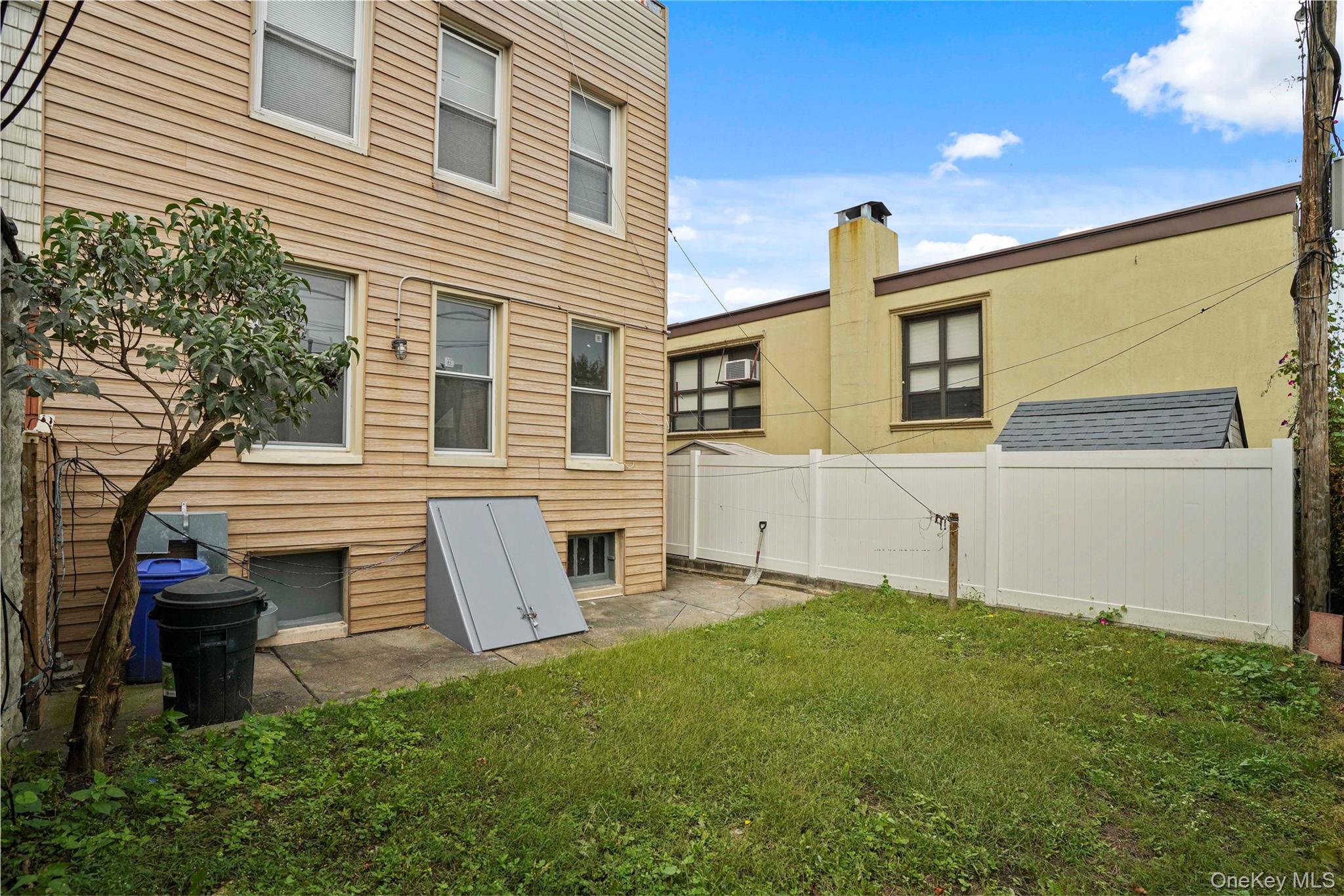 72-07 73rd Street Queens, NY 11385 - Photo 17 of 49 Rear view of house with a patio area and a chimney