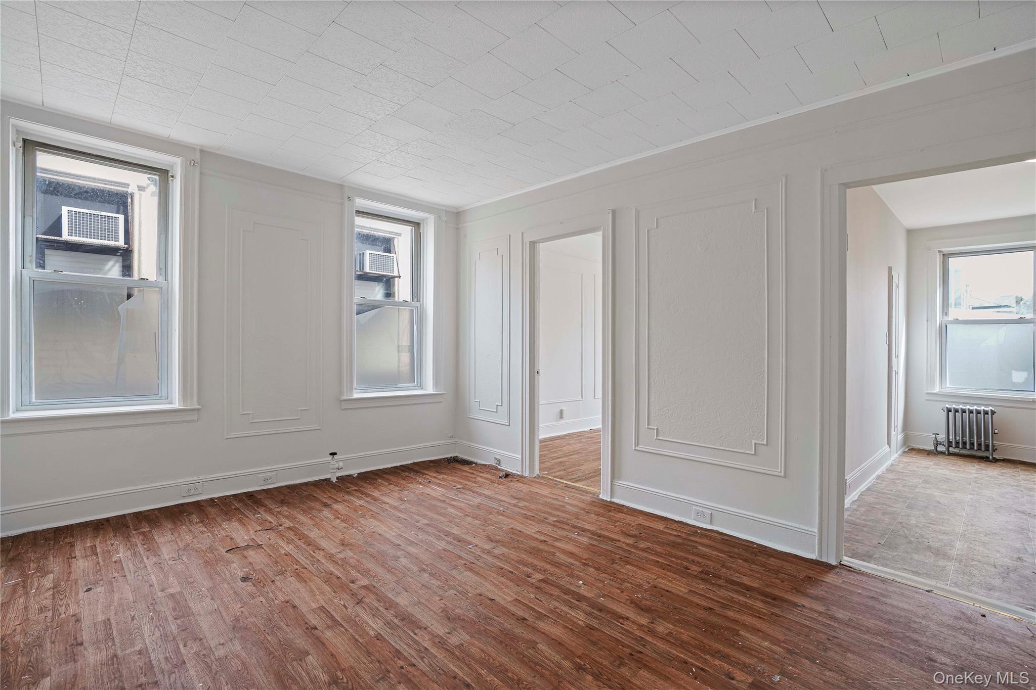 72-07 73rd Street Queens, NY 11385 - Photo 27 of 44 Unfurnished bedroom featuring wood-type flooring and radiator heating unit