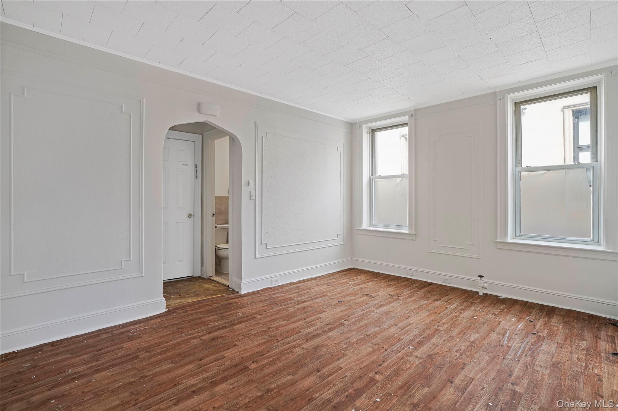 72-07 73rd Street Queens, NY 11385 - Photo 28 of 44 Spare room with arched walkways and wood finished floors