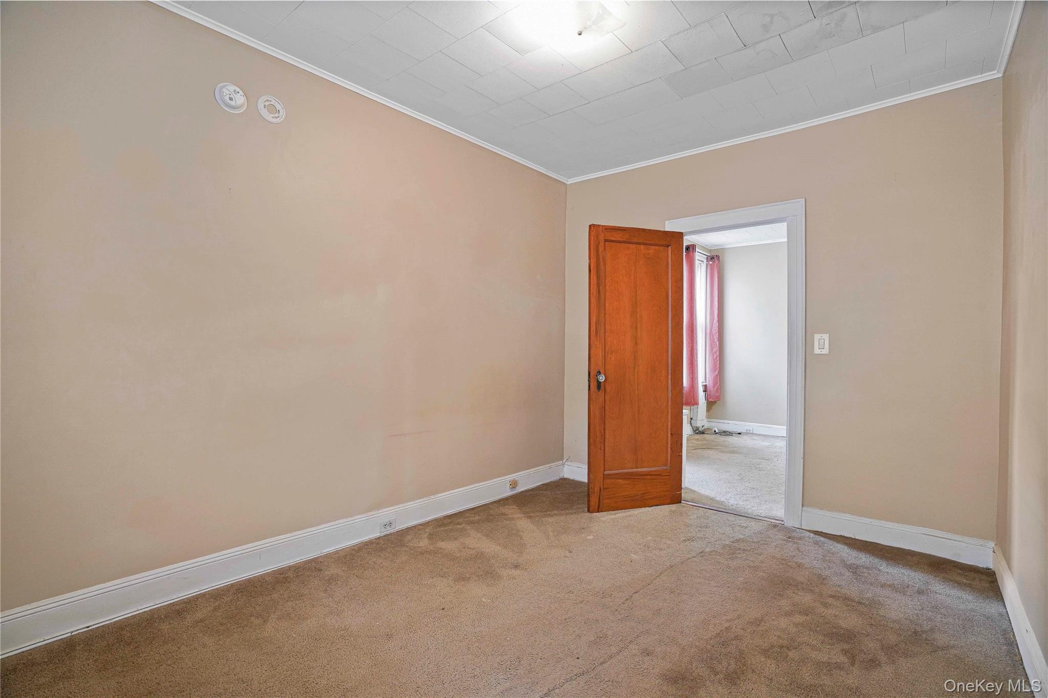 72-07 73rd Street Queens, NY 11385 - Photo 29 of 49 Empty room with crown molding and carpet flooring