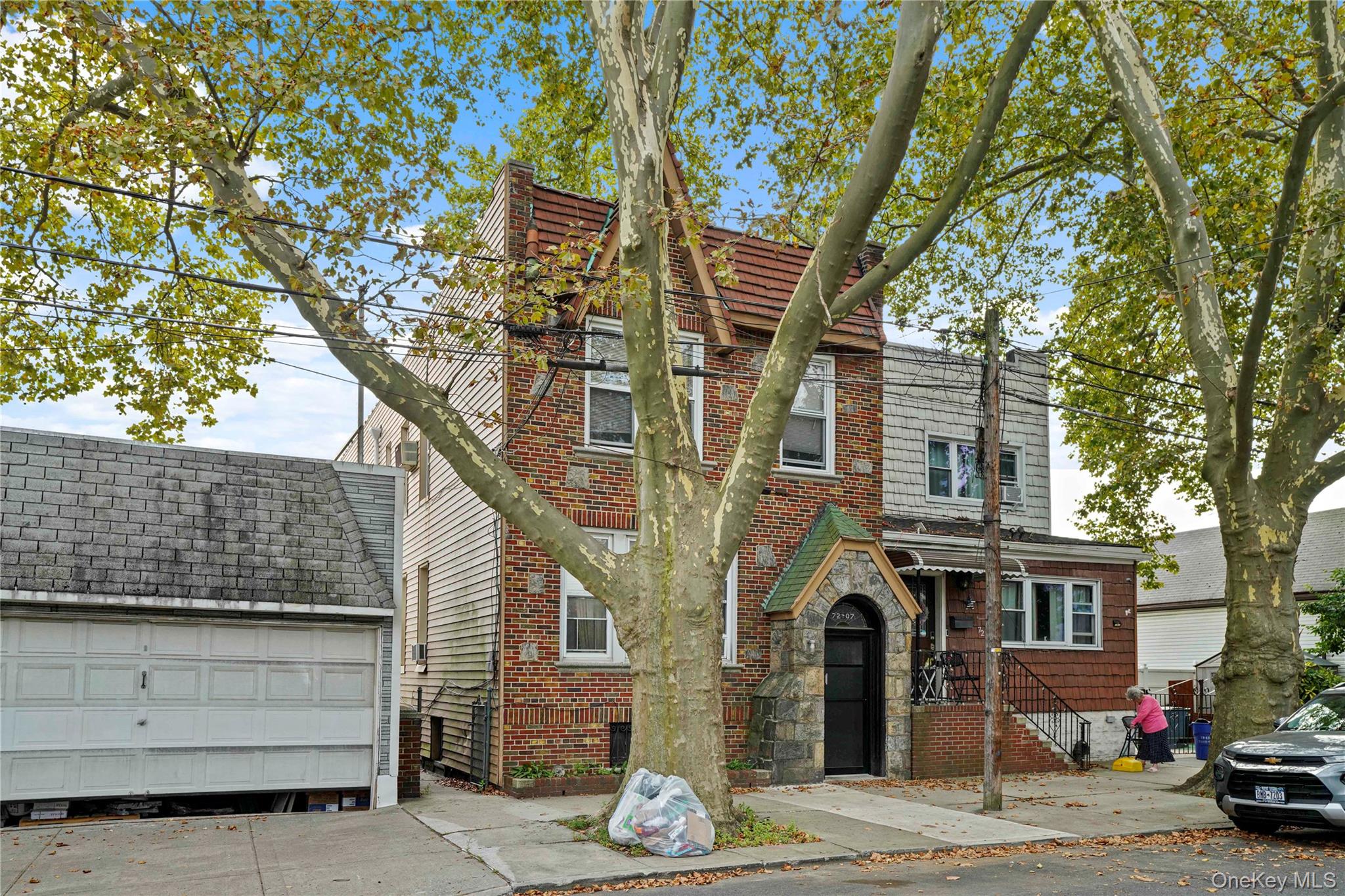 72-07 73rd Street Queens, NY 11385 - Photo 3 of 49 View of front of property with brick siding, stone siding, and a garage