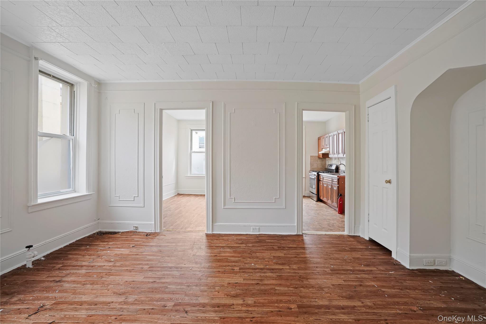 72-07 73rd Street Queens, NY 11385 - Photo 31 of 44 Unfurnished room featuring hardwood / wood-style flooring, plenty of natural light, and arched walkways
