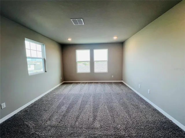 an empty room with a empty space and windows