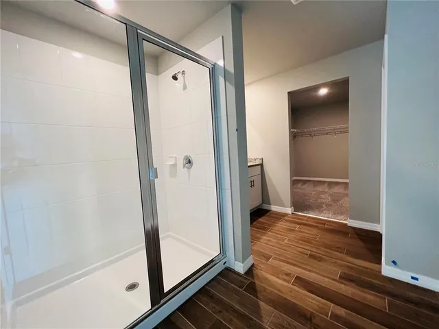 a bathroom with a glass shower door and a bathtub