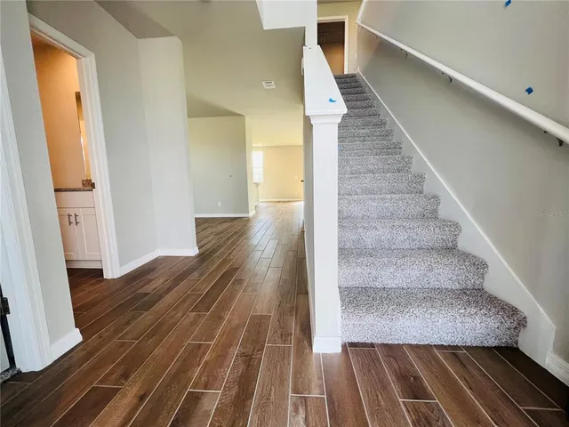 a view of entryway and hall with wooden floor
