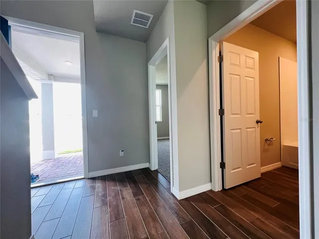 a view of a room with wooden floor and a hallway