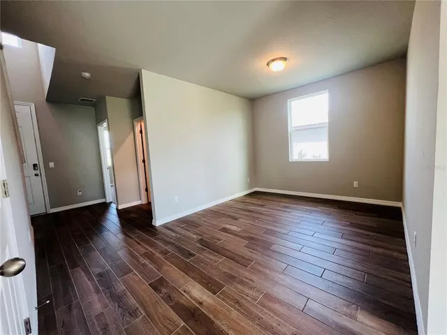 an empty room with wooden floor and a window