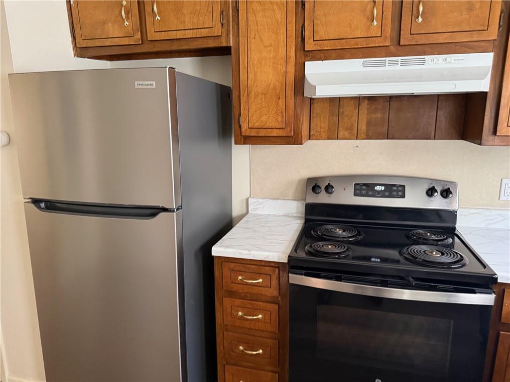 1085 Eastview Road Northeast Conyers, GA 30012 - Photo 5 of 14 a kitchen with a stove and a refrigerator with white cabinets