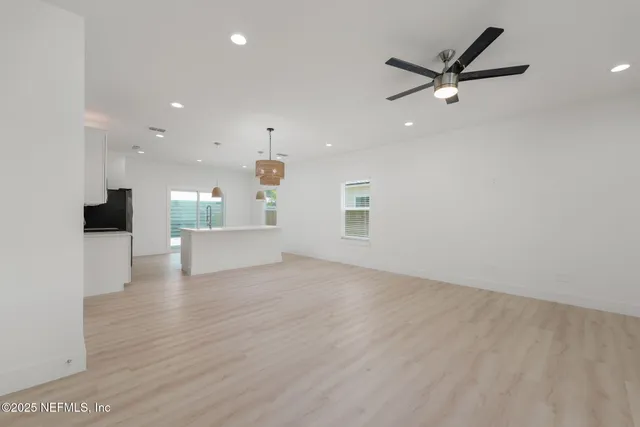 a view of a livingroom with a kitchen counter tops and a ceiling fan