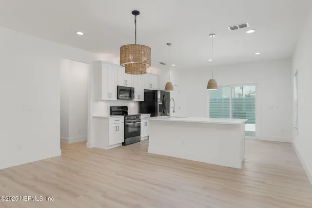 a view of kitchen with microwave refrigerator and stove