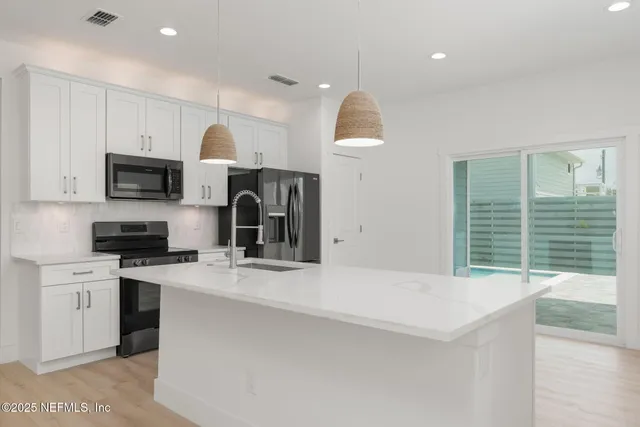 a kitchen with a sink a stove and cabinets