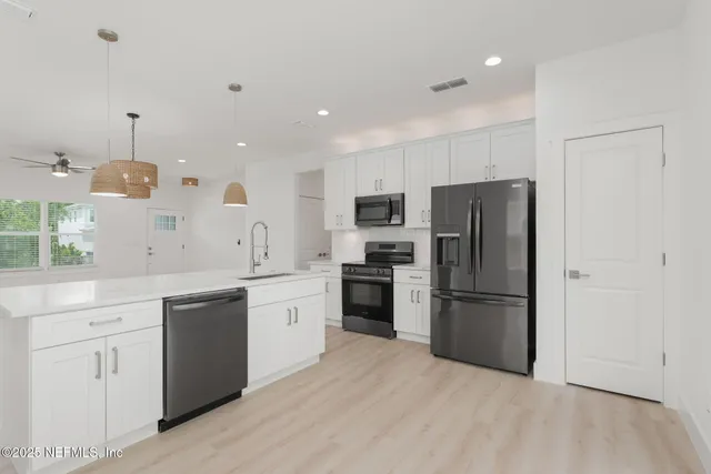 a kitchen with a refrigerator a sink and dishwasher a oven with wooden floor