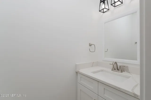 a bathroom with a granite countertop sink and vanity