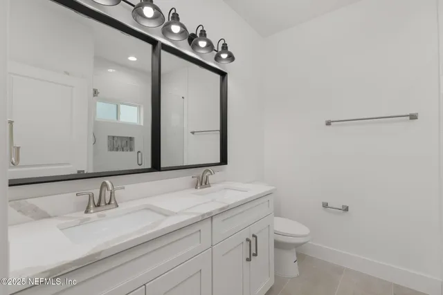 a bathroom with a sink vanity granite and toilet