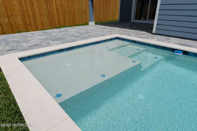 a view of backyard with wooden fence