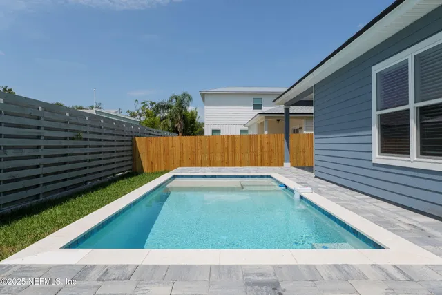 a backyard of a house with plants and wooden fence
