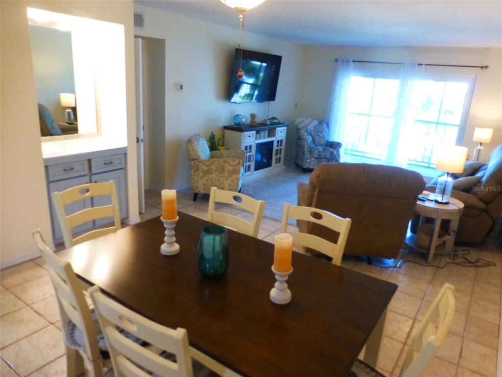 5557 Sea Forest Drive, Unit 215 New Port Richey, FL 34652 - Photo 13 of 42 a living room with dining table