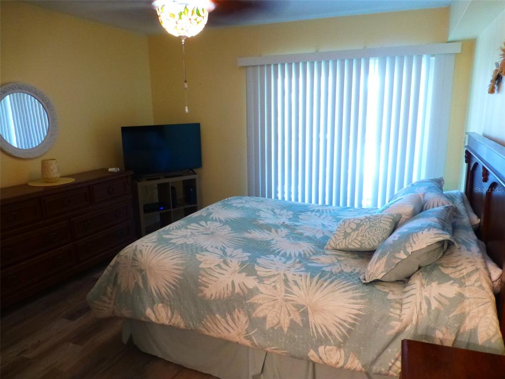 5557 Sea Forest Drive, Unit 215 New Port Richey, FL 34652 - Photo 25 of 42 a bedroom with a bed and a chandelier