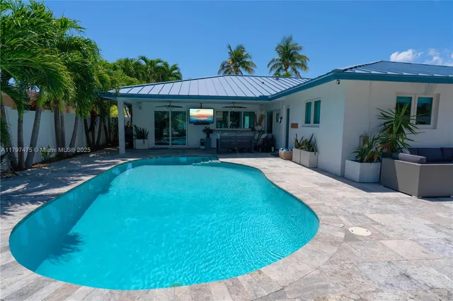 a view of a house with a swimming pool and sitting area