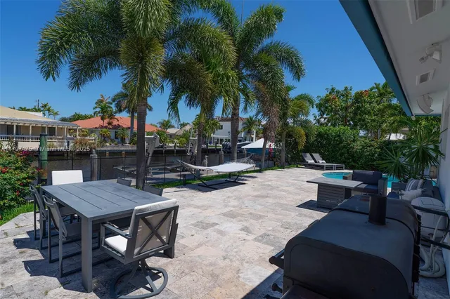 a view of a patio with table and chairs potted plants and palm tree