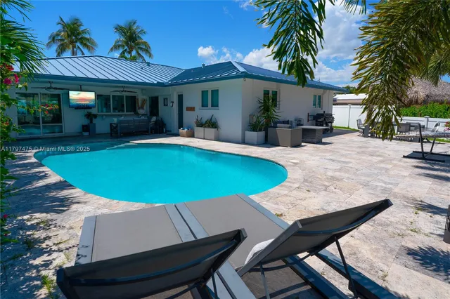 a view of a house with swimming pool and sitting area