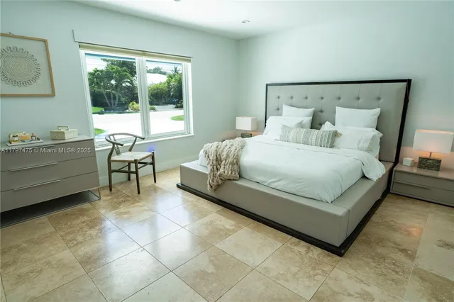 a bedroom with a bed chair and a window