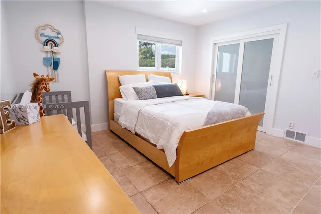 a bed sitting in a bedroom next to a window