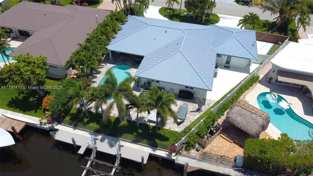 an aerial view of a house with a yard potted plants and large tree