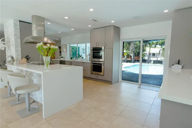 a kitchen with stainless steel appliances kitchen island granite countertop a sink and cabinets