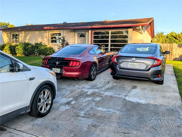 a blue car parked in front of a house