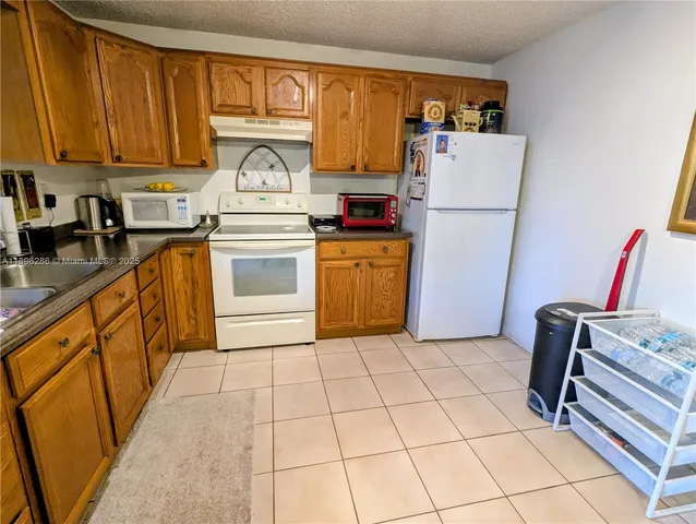 a kitchen with a refrigerator sink stove and cabinets