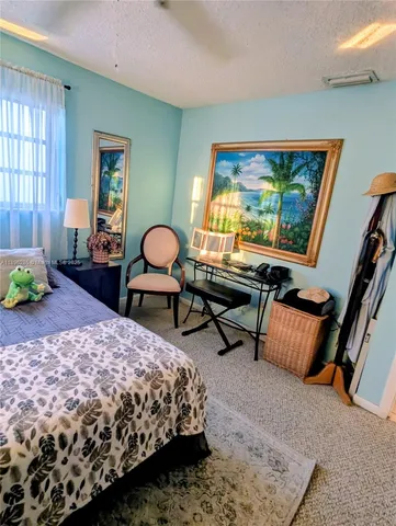 a bedroom with a bed dresser and window