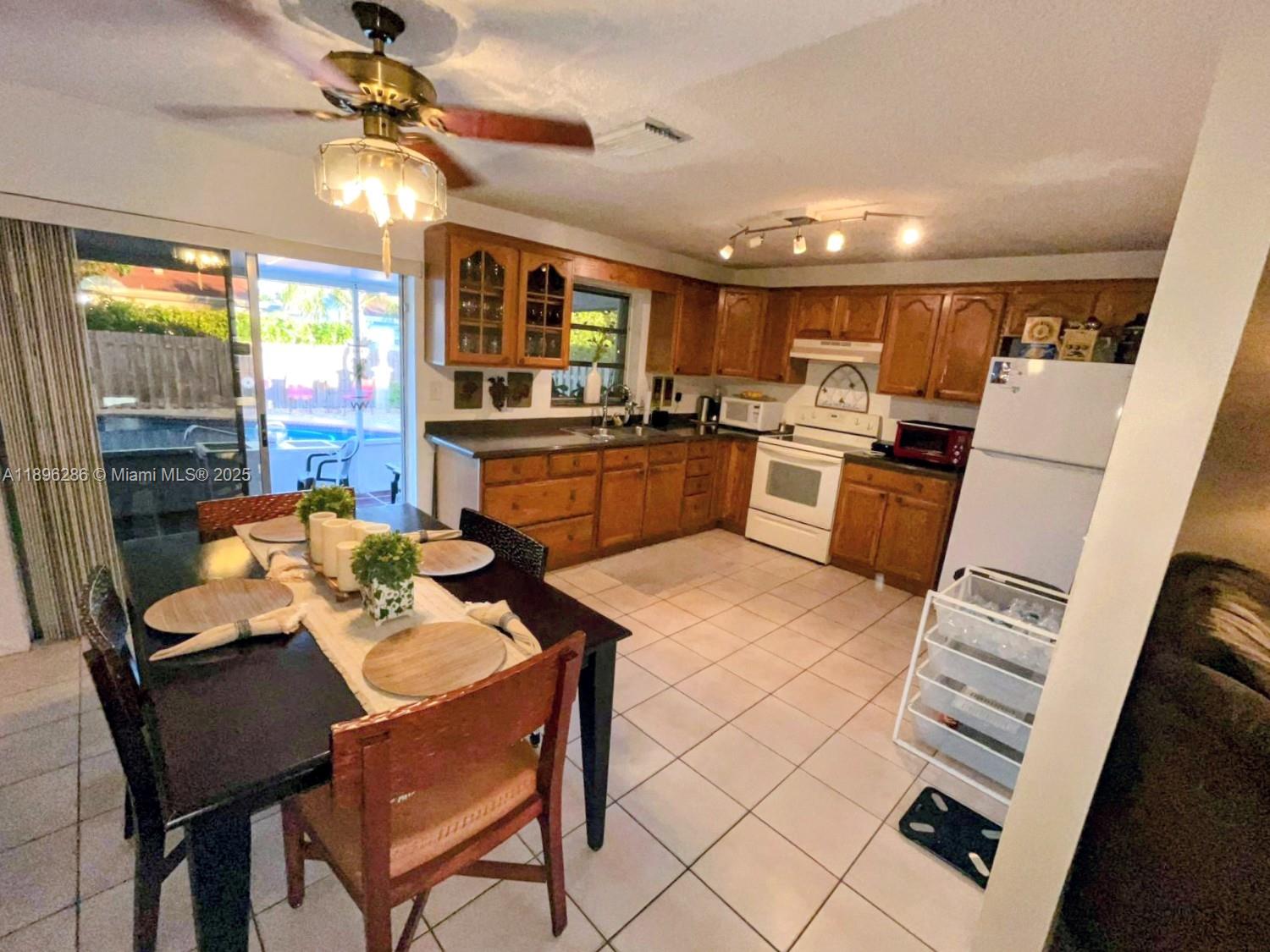 3031 Northwest 74th Avenue Hollywood, FL 33024 - Photo 8 of 34 a kitchen with sink refrigerator dining table and chairs