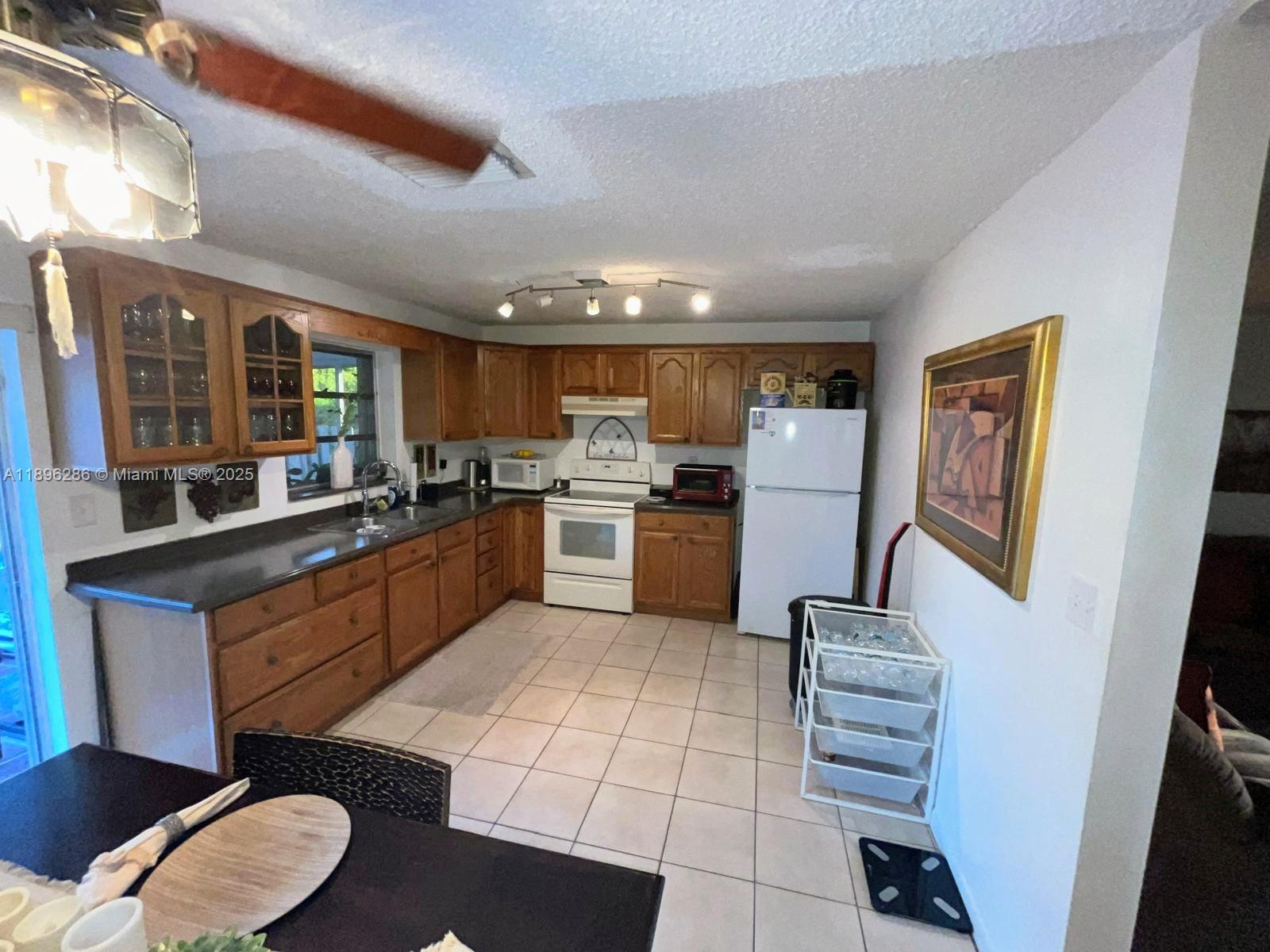3031 Northwest 74th Avenue Hollywood, FL 33024 - Photo 9 of 34 a kitchen with stainless steel appliances a refrigerator a sink dishwasher stove and oven