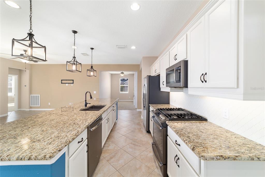 5670 Northwest 39th Lane Ocala, FL 34482 - Photo 19 of 61 a kitchen with stainless steel appliances granite countertop a sink stove and refrigerator