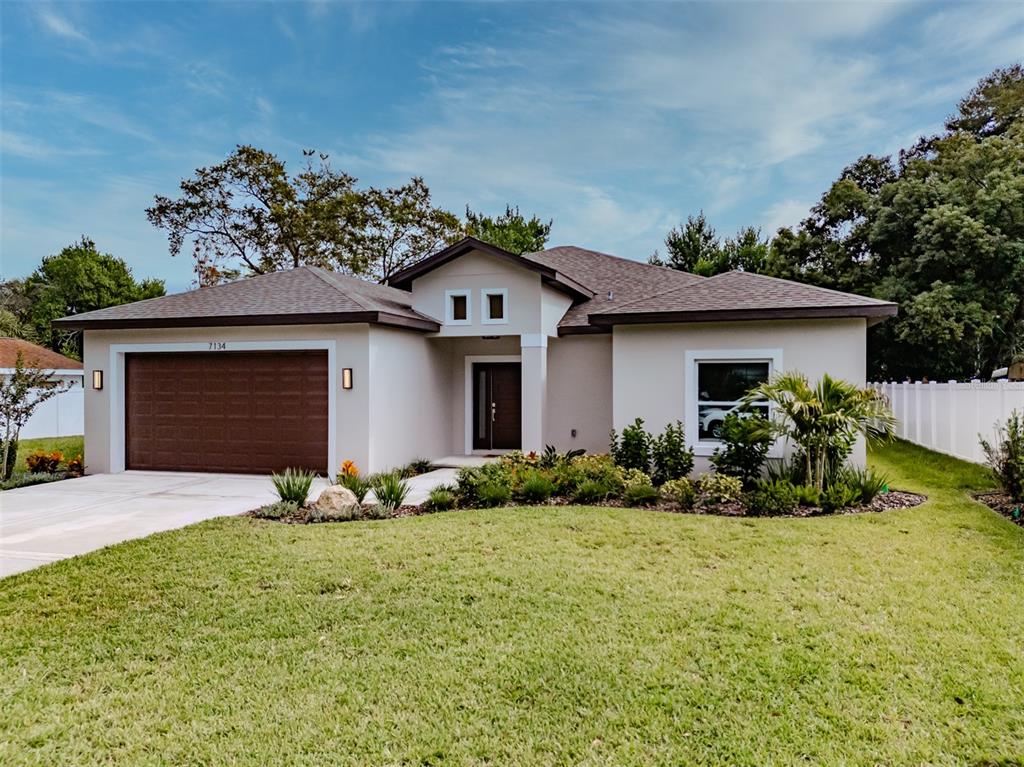 7134 Maclura Drive New Port Richey, FL 34653 - Photo 1 of 1 a front view of a house with a yard and garage