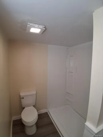 a white toilet sitting next to a shower