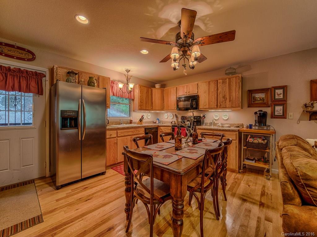 541 Chinquapin Road Canton, NC 28716 - Photo 9 of 23 a kitchen with stainless steel appliances kitchen island granite countertop a refrigerator a stove a microwave oven a sink with island and chairs