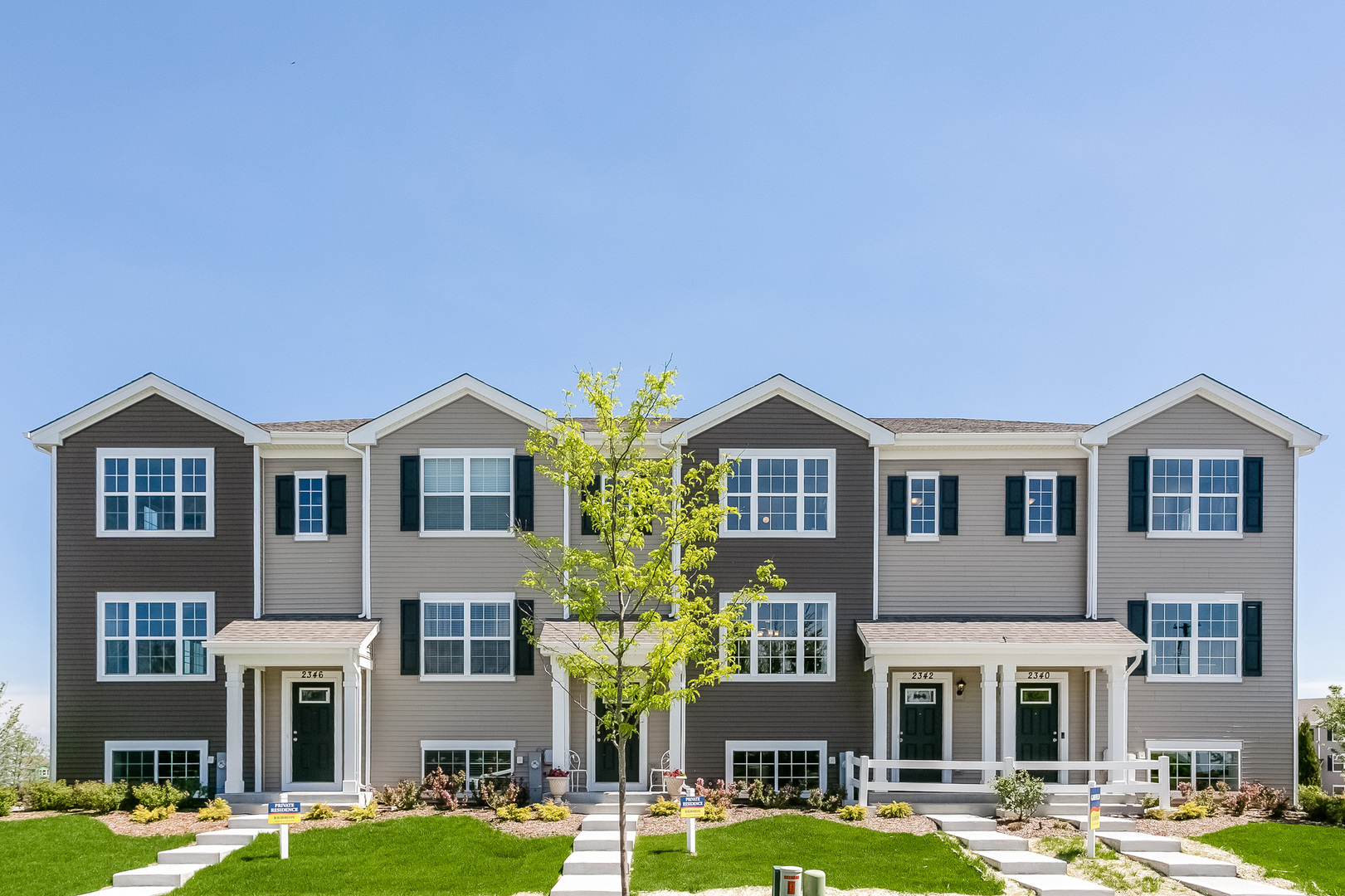 2350 Upland Road, Unit 2276 Pingree Grove, IL 60140 - Photo 1 of 18 a front view of a building with yard and trees