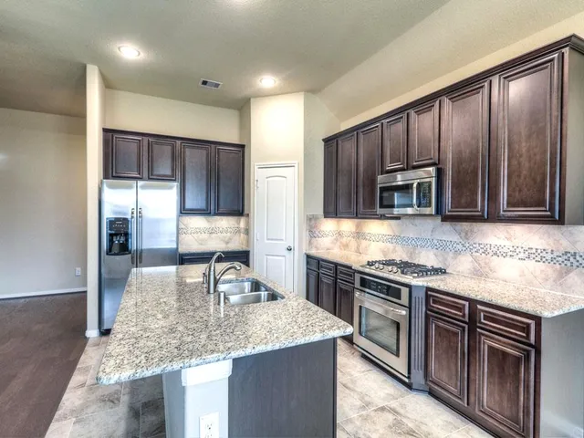 a kitchen with stainless steel appliances granite countertop a sink counter space and cabinets