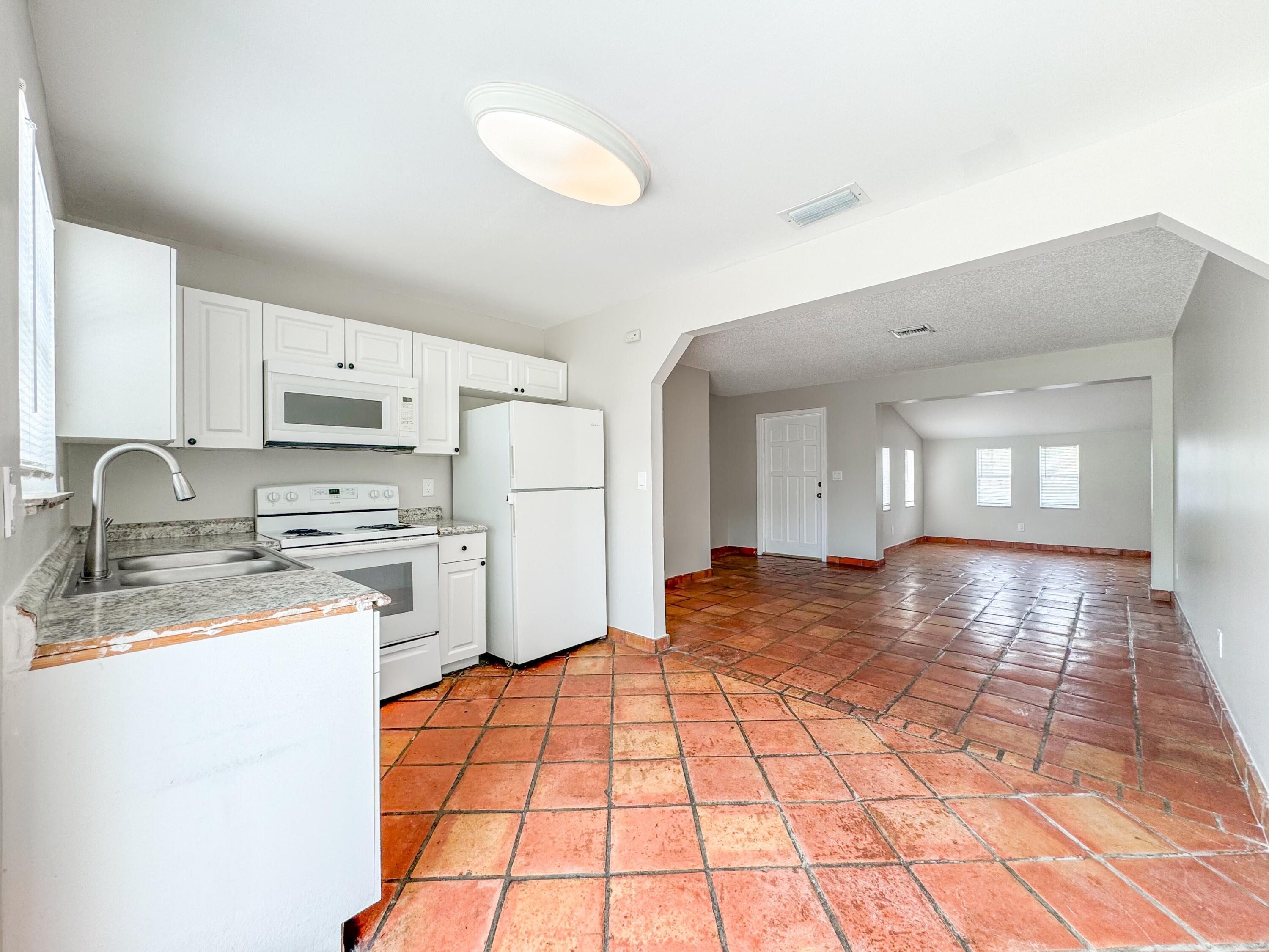 2735 Richard Road, Unit A West Palm Beach, FL 33403 - Photo 4 of 14 a view of a kitchen with a sink dishwasher refrigerator stove and a sink