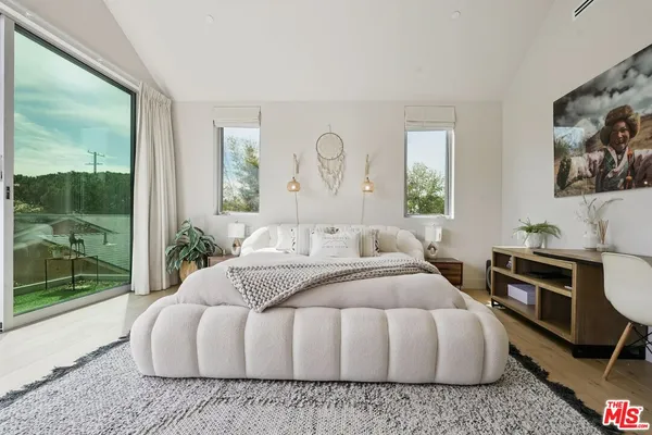 a bedroom with a bed wooden floor and window