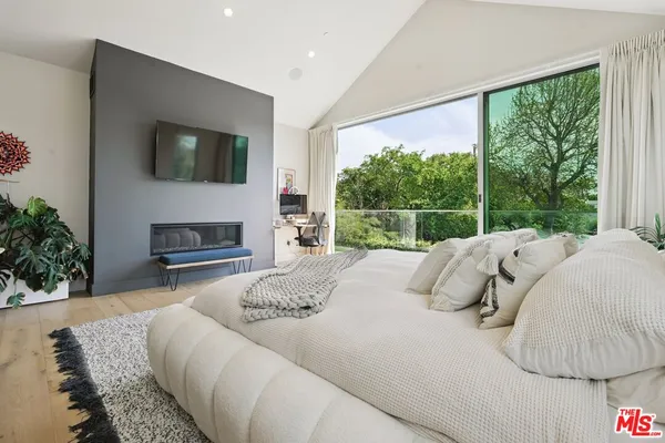 a bedroom with a bed and a flat screen tv