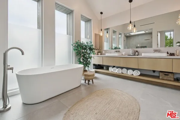 a bathroom with a bathtub a sink and a mirror