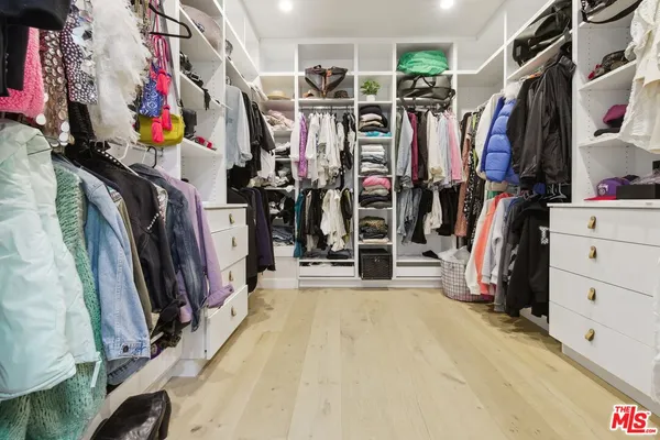 a view of walk in closet with clothes