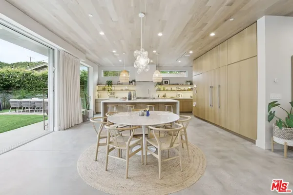 a view of a dining room with furniture large windows and wooden floor