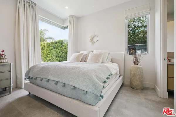 a bed sitting in a bedroom next to a window